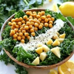- 1 bunch of kale, stems removed and leaves chopped - 1 can (15 oz) chickpeas, drained and rinsed - 2 tablespoons olive oil (divided) - Salt and pepper to taste - 1/4 cup grated Parmesan cheese (or nutritional yeast for a vegan option) - 1/2 cup Greek yogurt (or a vegan alternative) - 2 tablespoons lemon juice - 1 tablespoon Dijon mustard - 1 clove garlic, minced - 1/4 cup whole wheat croutons (optional) - Freshly cracked black pepper for garnish This list gives you everything you need for a tasty Kale Caesar Salad with Crispy Chickpeas. Fresh kale is the star here, with its sturdy leaves that hold up well. Chickpeas add protein and crunch, making the salad filling. Olive oil is key to making the chickpeas crispy and adding flavor to the kale. Salt and pepper enhance all the tastes. For a cheesy kick, you can use grated Parmesan cheese or nutritional yeast if you prefer a vegan dish. The dressing includes Greek yogurt for creaminess, which you can swap for a vegan yogurt if needed. Lemon juice brings brightness, while Dijon mustard and garlic add a punch. If you want to elevate the salad, consider adding whole wheat croutons for extra texture. Finally, sprinkle freshly cracked black pepper on top to finish it off. Feel free to explore the Full Recipe for detailed instructions! First, preheat your oven to 400°F (200°C). This is key for roasting the chickpeas. Next, we need to prepare the kale. Grab a large bowl and add the chopped kale leaves. Drizzle one tablespoon of olive oil over the kale. Now, massage the leaves for about 2-3 minutes. This step makes the kale tender and easier to eat. For the chickpeas, rinse and drain them well. Place them on a baking sheet. Toss the chickpeas with one tablespoon of olive oil, salt, and pepper. Spread them out evenly on the sheet. Roast them in the oven for 25-30 minutes. They should turn golden brown and crispy. Don’t forget to shake the pan halfway through cooking to ensure even crispiness. While the chickpeas roast, let's make the dressing. In a small bowl, mix Greek yogurt, lemon juice, Dijon mustard, minced garlic, and half the grated Parmesan cheese. Whisk until smooth. Taste and adjust with salt and pepper as needed. Once the chickpeas are crispy, take them out of the oven. Now, toss the massaged kale with the dressing until it’s well coated. Add the crispy chickpeas on top, along with croutons if you want some extra crunch. Mix gently to combine everything. Serve your Kale Caesar Salad with crispy chickpeas topped with the remaining Parmesan cheese and a sprinkle of freshly cracked black pepper. Enjoy this delicious meal! For the full recipe, check out the complete guide to make this dish perfectly. To make crispy chickpeas, start by ensuring they are dry. After draining and rinsing, pat them with a towel. This removes moisture. Next, toss the chickpeas in olive oil, salt, and pepper. Spread them evenly on a baking sheet. Roast them in a preheated oven at 400°F for 25-30 minutes. Shake the pan halfway through to ensure even cooking. You want them golden brown and crunchy. For seasoning, try adding garlic powder or smoked paprika. These spices add great flavor. Balance is key. You want enough seasoning to taste but not overwhelm the chickpeas. To add more flavor, consider toppings like cherry tomatoes or avocado slices. These fresh ingredients add color and taste. You can also use nuts like almonds or walnuts for crunch. For a creamy dressing, Greek yogurt is perfect. It adds a rich texture. Mix it with lemon juice, Dijon mustard, and minced garlic. This blend creates a zesty flavor. You can replace Greek yogurt with a vegan alternative if needed. When serving, use large bowls or a platter. This creates a family-style meal. Layer the kale and chickpeas for a colorful look. Top with extra crispy chickpeas and lemon wedges. These garnishes add brightness. For visual appeal, sprinkle freshly cracked black pepper on top. This simple touch enhances the salad's look and taste. You can also add fresh herbs like parsley for a pop of color. This makes your Kale Caesar Salad with Crispy Chickpeas even more inviting! For the full recipe, check out the complete guide. {{image_2}} You can switch out kale for other greens. Try romaine, spinach, or even arugula. Each green brings its own taste and crunch. Mixing greens can make your salad fun and unique. You can also add other salad ingredients. Think about cherry tomatoes, cucumbers, or bell peppers. These add color and flavor to your dish. Want to make your salad heartier? Add some protein! Grilled chicken works well and adds great flavor. If you're vegan, try adding tofu. Just sauté it until golden. This way, you create a well-balanced meal. Protein helps you feel full longer. You can also mix in beans or lentils for a plant-based option. Switch up your dressing for different flavors. You can use tahini or avocado for a creamy touch. A vinaigrette made from olive oil and balsamic vinegar is also tasty. For a vegan option, mix hummus with water to thin it out. This gives a nice texture and taste. Feel free to experiment with your favorite herbs and spices too! For the full recipe, check out the section above. To keep your Kale Caesar Salad fresh, store leftovers in the fridge. Use an airtight container to seal in moisture. You can also separate the crispy chickpeas from the salad. This keeps them crunchy. Storing them together can make the chickpeas soggy. If you have leftover dressing, keep it in a small jar or container. The salad components last about three days in the fridge. The kale will stay fresh for longer if you wash it properly. Chickpeas can last up to five days when stored well. Watch for signs of spoilage. If the kale wilts or turns brown, it’s time to toss it. Also, check for a sour smell or strange textures in the dressing. Crispy chickpeas taste best when reheated in the oven. Preheat the oven to 350°F (175°C). Spread the chickpeas on a baking sheet and heat for about 10 minutes. This helps them regain their crunch. Avoid using the microwave, as it makes them chewy. Enjoy your salad fresh, with crispy chickpeas on top for the best flavor and texture. For the full recipe, refer to Kale Caesar Salad with Crispy Chickpeas. Yes, you can prep parts of this salad in advance. Here are some tips: - Wash and chop the kale a day before. Store it in a sealed bag. - Roast the chickpeas earlier and keep them in an airtight container. - Mix your dressing and store it in the fridge. This keeps it fresh. - Combine the kale, chickpeas, and dressing just before serving. This way, the salad stays crisp. If you want a dairy-free option, try these vegan cheese alternatives: - Nutritional yeast gives a cheesy flavor. Use it in the same amount as Parmesan. - Vegan Parmesan is also available in stores. It adds a similar taste. - Blended cashews can create a creamy texture. Soak them in water and blend until smooth. These options keep your salad tasty while fitting your dietary needs. To make this salad gluten-free, follow these options: - Use gluten-free croutons or skip them altogether. You can add nuts for crunch. - Ensure that your Dijon mustard is gluten-free. Most brands are, but check the label. - The rest of the ingredients are naturally gluten-free. This makes the salad easy to adapt. By making these small changes, you can enjoy a safe, gluten-free meal. This blog post covered how to make a tasty kale salad with crispy chickpeas. We explored ingredients, step-by-step cooking, tips for great flavor, and storage ideas. You can easily swap out ingredients or add proteins to fit your taste. Remember, making this salad ahead saves time and keeps your meals fresh. Enjoy experimenting with flavors and variations. Happy cooking!