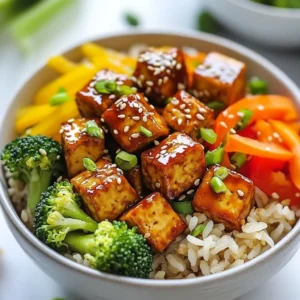 To make Teriyaki Tofu Rice Bowls, gather these key items: - 1 block (14 oz) firm tofu, pressed and cubed - 1 cup brown rice - 2 cups vegetable broth (or water) - 1 cup broccoli florets - 1 bell pepper, sliced (any color) - 1 carrot, julienned - 2 tablespoons vegetable oil - 1 tablespoon sesame oil - 4 tablespoons soy sauce - 2 tablespoons mirin (or substitute with additional honey or agave syrup) - 2 tablespoons honey (or agave syrup for vegan option) - 1 teaspoon grated fresh ginger - 1 garlic clove, minced - 1 tablespoon sesame seeds - Green onions, chopped for garnish These ingredients create a perfect balance of flavors and textures. Measuring your ingredients helps keep the dish tasty and balanced. Use a liquid measuring cup for the vegetable broth and a dry one for the rice. Make sure to press the tofu well. This step removes excess water and helps the tofu absorb flavor. Each ingredient plays a role. The rice serves as a hearty base, while the tofu adds protein and richness. The vegetables bring color and crunch. You can customize your Teriyaki Tofu Rice Bowls easily. If you want a different grain, use quinoa or jasmine rice instead of brown rice. For the tofu, try tempeh for a unique flavor. If you need a soy-free option, coconut aminos works well in place of soy sauce. You can also swap out vegetables based on your tastes. Snow peas, zucchini, or mushrooms make great alternatives. Just remember, keep the cooking times similar for best results. {{ingredient_image_1}} To start, rinse 1 cup of brown rice under cold water. This helps remove excess starch. Next, combine the rinsed rice and 2 cups of vegetable broth or water in a pot. Bring this mixture to a boil. Once boiling, reduce the heat to low. Cover the pot and let it simmer for about 45 minutes. The rice is ready when all the liquid is absorbed. Fluff the rice with a fork and set it aside. While the rice cooks, you can whip up the teriyaki sauce. In a small bowl, mix together 4 tablespoons of soy sauce, 2 tablespoons of mirin, and 2 tablespoons of honey. Add in 1 teaspoon of grated fresh ginger and 1 minced garlic clove. Whisk it all together until smooth. Set this tasty sauce aside for later. Now, let’s turn to the tofu. Heat 2 tablespoons of vegetable oil in a large skillet over medium-high heat. Once hot, add 1 block of pressed and cubed tofu. Cook the tofu for about 5 to 7 minutes. You want it to be golden brown on all sides. This step adds great flavor and texture. After browning, pour the teriyaki sauce over the tofu. Let it simmer for 2 to 3 minutes so the sauce thickens a bit. In another skillet, heat 1 tablespoon of sesame oil over medium heat. Add 1 cup of broccoli florets, 1 sliced bell pepper, and 1 julienned carrot. Stir-fry these veggies for about 5 minutes. You want them to be tender but still crisp. This adds a nice crunch to your bowls. Now it’s time to put it all together! Start with a generous scoop of the brown rice at the bottom of each bowl. Top it with the glazed tofu and the stir-fried vegetables. For a finishing touch, sprinkle sesame seeds on top and add chopped green onions for color and flavor. Enjoy your Teriyaki Tofu Rice Bowls! Tofu holds water, which makes it less tasty. Pressing removes this water. Wrap the tofu in a clean towel. Place a heavy object on top, like a skillet or canned goods. Let it sit for at least 15 to 30 minutes. This step helps the tofu absorb flavors better. A good teriyaki sauce is key. Start with soy sauce for saltiness. Mirin adds sweetness and a hint of tang. Honey or agave syrup can enhance this sweetness too. Fresh ginger brings warmth, and garlic adds depth. Mix all these ingredients well, and let them sit a few minutes. This lets the flavors blend and grow strong. Timing is crucial for cooking vegetables. Heat your skillet well before adding oil. Use medium heat for even cooking. Add the broccoli, bell pepper, and carrot together. Stir-fry them for about 5 minutes. You want them tender but still crisp. This keeps their bright colors and nutrients intact. Enjoy the fresh taste they bring to your bowl. Pro Tips Press Tofu Well: Make sure to press the tofu for at least 30 minutes to remove excess moisture. This helps it absorb more flavor and achieve a crispy texture when cooked. Customize Vegetables: Feel free to swap in your favorite vegetables based on what you have on hand or what’s in season. Zucchini, snap peas, or bok choy can work beautifully in this dish. Make Extra Sauce: If you love a saucy bowl, consider doubling the teriyaki sauce ingredients. You can drizzle more over the assembled bowls for added flavor. Garnish Generously: Don’t skip the garnishes! Fresh green onions and sesame seeds add not only flavor but also a lovely visual appeal to your rice bowls. {{image_2}} You can easily make this dish vegan. Just use agave syrup instead of honey. For a gluten-free option, choose gluten-free soy sauce. Many brands offer this. This way, you still enjoy the sweet and savory taste of teriyaki. Feel free to mix in other veggies. Snow peas, snap peas, or zucchini work well. You can also add mushrooms for a meaty texture. These changes keep your bowl fresh and exciting. Each vegetable adds unique flavors and colors. You can boost flavor with spices and herbs. Try adding red pepper flakes for heat. A sprinkle of Chinese five-spice adds depth. Fresh cilantro or basil can brighten the dish. Experiment with what you love. Each addition makes your rice bowl special. To keep your Teriyaki Tofu Rice Bowls fresh, store them in airtight containers. Let the bowls cool down before sealing them. This helps prevent moisture buildup. You can keep them in the fridge for up to three days. If you want to enjoy them later, portion them out. This makes reheating easier. When it's time to eat your leftovers, reheating is key. Use the microwave for quick meals. Place your rice bowl in a microwave-safe dish. Add a splash of water to keep the rice moist. Cover it with a lid or microwave-safe wrap. Heat for about 2-3 minutes. Stir halfway through for even heating. If you want crispy tofu again, reheat it in a skillet. Warm it over medium heat for 5-7 minutes. Freezing is a great way to save your Teriyaki Tofu Rice Bowls. Make sure to cool the bowls completely. Then, divide them into single portions. Use freezer-safe containers or bags. Label them with the date. They can last for about three months in the freezer. To reheat, let them thaw in the fridge overnight. Then, use the microwave or skillet as mentioned above. Enjoy your tasty meal anytime! You can easily make Teriyaki Tofu Rice Bowls vegan. Just replace honey with agave syrup. This simple swap keeps the sweetness. All other ingredients in the recipe are already vegan. Tofu, rice, and veggies are all plant-based. Yes, you can use different types of rice. White rice, jasmine rice, or even quinoa works well. Each type of rice gives a unique taste and texture. Just adjust the cooking time as needed. For example, white rice cooks faster than brown rice. You can pair many things with Teriyaki Tofu Rice Bowls. Try adding edamame for protein. You can also serve with a side salad for freshness. Pickled vegetables or seaweed salad adds extra flavor. These sides will make your meal more exciting! You can store leftovers in the fridge for about three to four days. Make sure to keep them in an airtight container. This helps maintain freshness and flavor. When you're ready to enjoy them, simply reheat in the microwave or on the stove. Teriyaki tofu rice bowls are easy to make and fun to enjoy. We covered the key ingredients, cooking steps, and tips to perfect your dish. You can try different veggies and flavors, too, to make it your own. Store your leftovers right for the best taste later. Now you have everything to create a tasty meal at home. Enjoy the process and savor every bite!