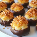 To make the best chocolate dipped coconut macaroons, you need a few simple items. Here’s the list of ingredients: - 3 cups shredded unsweetened coconut - 1 cup sweetened condensed milk - 1 teaspoon vanilla extract - 1/4 teaspoon almond extract - 1/4 teaspoon salt - 8 ounces semi-sweet chocolate chips - 1 tablespoon coconut oil Each ingredient plays a key role in the flavor and texture of your macaroons. The shredded coconut gives that delightful chew. Sweetened condensed milk adds sweetness and moisture. Vanilla and almond extracts enhance the flavor, while salt balances it all. For the chocolate coating, semi-sweet chocolate chips melt well and taste great. Coconut oil helps the chocolate stay smooth and shiny when melted. Make sure to use unsweetened coconut for the best results. Gather these items, and you’ll be ready to create a treat that everyone will love! {{ingredient_image_1}} First, preheat your oven to 325°F (163°C). This temperature is perfect for baking macaroons. While the oven heats, grab a baking sheet and line it with parchment paper. This step helps prevent sticking and makes clean-up easy. In a large bowl, mix together the shredded coconut and sweetened condensed milk. Stir until they blend well. Next, add the vanilla extract, almond extract, and salt. Mix again until everything is combined. The mixture should feel sticky and thick, which is just right. Now it's time to shape the macaroons. Use your hands to form small mounds, about 1.5 tablespoons each. Place them on the baking sheet, making sure to leave some space between each mound. Bake them for about 15 to 20 minutes. Keep an eye on them; you want the tops to turn golden brown. While the macaroons cool, melt the chocolate. In a microwave-safe bowl, add the semi-sweet chocolate chips and coconut oil. Heat them in 30-second intervals. Stir after each interval until the mixture is smooth. Be careful not to overheat the chocolate. Once the macaroons are cool, dip the bottom half of each one into the melted chocolate. Let the excess chocolate drip off. Place the dipped macaroons back on the parchment paper. To speed up the hardening, you can put them in the fridge for 10 to 15 minutes. Enjoy the sweet, chocolatey goodness! To get the best texture, use unsweetened coconut. It helps your macaroons stay moist and fluffy. Mix the coconut with sweetened condensed milk well. This step is key for a good blend. When forming the mounds, keep them small. About 1.5 tablespoons works best. This size ensures even baking and a nice bite. Watch the macaroons closely while they bake. Set a timer for 15 minutes. Check for a light golden color on top. If they start to brown too fast, lower the oven temperature by 10°F. This way, you keep them soft inside and avoid burning. Presentation can make your macaroons stand out. Arrange them on a pretty platter. For a fancy touch, sprinkle toasted coconut on top. You can also drizzle more melted chocolate over them. This adds a nice look and extra flavor. Pro Tips Use Fresh Coconut: For an even more tropical flavor, consider using fresh coconut instead of pre-packaged shredded coconut. It adds a delightful texture and taste! Chocolate Quality Matters: Opt for high-quality chocolate chips for dipping. The better the chocolate, the richer the flavor of your macaroons will be. Cool Completely: Ensure the macaroons are completely cooled before dipping them in chocolate. This helps the chocolate adhere better and prevents melting. Experiment with Flavors: Try adding different extracts or a pinch of sea salt on top of the chocolate for a gourmet touch. Almond, orange, or mint extracts can elevate the flavor profile! {{image_2}} You can make your macaroons even better with fun add-ins. Try mixing in some chopped nuts. Almonds, walnuts, or pecans work great. You can also add dried fruits like cranberries or apricots. These add a nice chew and a burst of flavor. Just make sure to keep the total amount of mix-ins around one cup. If you want to switch up the chocolate, you have choices! Dark chocolate gives a rich taste. White chocolate adds a sweet and creamy flavor. If you need a dairy-free option, use dairy-free chocolate chips. Just melt them the same way as semi-sweet chocolate. Each option changes the taste and look of your macaroons. You can have fun with the shapes and sizes of your macaroons. For bite-sized treats, make smaller mounds. They are perfect for parties or snacks. If you want a showstopper, form giant macaroons. Just remember to adjust the baking time, as larger ones may take longer to cook through. This way, your macaroons can fit any occasion! To keep your macaroons fresh, store them in an airtight container. Place parchment paper between layers to avoid sticking. Keep the container at room temperature for the best taste. If you live in a humid area, refrigeration helps. Just remember, cold air can change the texture. Freezing is a great option if you want to save some for later. First, let the macaroons cool completely. Then, place them in a single layer on a baking sheet. Freeze for about an hour. Once firm, transfer them to a freezer bag. Seal it tightly and label it. To thaw, take them out and let them sit at room temperature for about 30 minutes. Homemade macaroons last about 5 days at room temperature. In the fridge, they stay good for about a week. If frozen, they can last up to three months. Just remember that the sooner you eat them, the fresher they will taste. Yes, you can make these macaroons vegan. To do this, you need to replace the sweetened condensed milk. You can use a vegan sweetened condensed milk or make your own. Blend coconut milk with sugar until thick. This way, you keep the yummy taste while making it vegan. To keep your macaroons from falling apart, make sure you mix well. Use enough sweetened condensed milk to bind the coconut. When forming the mounds, press them tightly. This helps them hold their shape during baking. Baking them until golden brown also helps firm them up. To temper chocolate, use a double boiler. Heat the chocolate gently while stirring. You want it smooth but not too hot. Remove from heat and let it cool slightly. This gives you shiny chocolate. You can also use the microwave. Heat in short bursts, stirring often. You can buy Chocolate Dipped Coconut Macaroons at many grocery stores. Look for them in the bakery section. You can also find them at specialty shops or online. Check sites like Amazon or local bakeries. They often have fresh, tasty options. You now have a complete guide to making delicious coconut macaroons. From the simple ingredients to step-by-step baking instructions, you can create this treat with ease. Remember to focus on texture and presentation for the best results. Don’t hesitate to experiment with flavors and shapes. Enjoy these tasty bites fresh or stored for later. The joy of homemade treats can make any day special. So gather your ingredients and get started on your macaroons today!