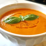 To make creamy roasted red pepper soup, you need: - 4 large red bell peppers - 1 medium onion, chopped - 3 cloves garlic, minced - 1 medium carrot, diced - 1 teaspoon smoked paprika - 4 cups vegetable broth - 1 cup heavy cream or coconut cream for dairy-free - 2 tablespoons olive oil - Salt and pepper to taste - Fresh basil or parsley for garnish If you want a dairy-free version, use coconut cream instead of heavy cream. You can also skip the cream altogether for a lighter soup. For added flavor, try adding a splash of lemon juice or a few drops of hot sauce. You can also swap regular vegetable broth for low-sodium broth to cut down on salt. Garnishes add color and taste. Some good choices include: - Chopped fresh basil - Fresh parsley - A drizzle of olive oil - A sprinkle of smoked paprika - Croutons for crunch These garnishes make your soup look nice and taste even better. Feel free to mix and match based on what you like! {{ingredient_image_1}} First, preheat your oven to 425°F (220°C). Take your four large red bell peppers and cut them in half. Remove the seeds and stems. Place the peppers cut side down on a baking sheet. Roast them in the oven for about 25 to 30 minutes. You want the skins to blister and char. This step adds a rich flavor to your soup. While the peppers roast, heat two tablespoons of olive oil in a large pot over medium heat. Add one chopped medium onion to the pot. Sauté the onion for about five minutes until it looks clear. Then, add three minced garlic cloves and one diced medium carrot. Sauté this mix for another three to four minutes. The smell will be amazing as the carrot softens. After roasting, take the peppers out of the oven and let them cool for a few minutes. Once they are cool enough to handle, peel off the charred skin and chop the peppers. Add the chopped peppers to the pot with the sautéed aromatics. Mix in one teaspoon of smoked paprika and four cups of vegetable broth. Bring the mix to a simmer and cook for about 15 minutes. Then, use an immersion blender to blend the soup until it is smooth and creamy. If you don’t have an immersion blender, you can use a countertop blender in batches. Finally, stir in one cup of heavy cream or coconut cream. Season with salt and pepper to taste, then serve hot, garnished with fresh basil or parsley. Enjoy your delicious soup! Roasting peppers brings out their sweet and smoky flavor. Start by preheating your oven to 425°F (220°C). Cut the red bell peppers in half and remove the seeds and stems. Place them cut side down on a baking sheet. Roast for 25-30 minutes until the skins are blistered and charred. This step is key for a deep flavor. Let the peppers cool before peeling off the charred skin. To make your soup creamy, use heavy cream or coconut cream. After blending the soup, stir in the cream slowly. This helps you control the richness and texture. If you want a lighter version, use less cream. You can also blend longer for an even smoother finish. An immersion blender works best but a countertop blender can work too. Serve your soup hot with a garnish of fresh basil or parsley. This adds color and freshness. Pair the soup with crusty bread or a simple salad. For a heartier meal, try adding grilled chicken or beans. These additions make the soup a complete dish. Enjoy your flavorful creation! Pro Tips Roasting Tips: For even more flavor, try adding a splash of balsamic vinegar to the bell peppers before roasting. It enhances the sweetness and adds depth to the soup. Blending Technique: If you don't have an immersion blender, let the soup cool slightly before transferring it to a countertop blender. This will prevent splatters and ensure a smooth blend. Make it Spicy: For those who enjoy a kick, add a pinch of red pepper flakes or a dash of cayenne pepper when sautéing the onions and garlic. Garnishing Ideas: Enhance the presentation by drizzling a little extra cream or olive oil on top of the soup before serving. You can also add croutons for added texture. {{image_2}} You can easily change the flavor of your soup. Try adding different spices. For a smoky taste, use smoked paprika. To spice things up, add a pinch of cayenne pepper. You might also enjoy adding fresh herbs like thyme or rosemary. These will give your soup more depth. Don't be afraid to experiment until you find your favorite mix. For a heartier meal, consider adding proteins to the soup. You can stir in shredded cooked chicken for a filling option. If you prefer a plant-based choice, add cooked beans. White beans or chickpeas work well and add texture. This will make the soup more satisfying and boost the nutrition too. You can add other vegetables to change the soup's flavor. Carrots and onions are great, but you can also try zucchini or spinach. These veggies add color and nutrients. Roasted corn can bring a sweet touch. Chop them small and add them while cooking. This way, they blend well with the soup. Each veggie adds its own flair, making the soup your own unique dish. To keep your creamy roasted red pepper soup fresh, let it cool first. Once cool, pour it into an airtight container. Store it in the fridge for up to five days. Make sure to label the container for easy identification. If you want to save some for later, freezing is a good option. Pour the soup into freezer-safe bags or containers. Leave some space at the top for expansion. You can freeze it for up to three months. Thaw it in the fridge before reheating. To reheat, pour the soup into a pot. Heat it over medium-low until warm. Stir it often to avoid sticking. If it seems too thick, add a splash of broth or water. You can also use a microwave for quick reheating. Just heat in short intervals and stir in between. Enjoy your soup warm and creamy! Yes, you can make Creamy Roasted Red Pepper Soup ahead of time. It tastes even better the next day! Just let it cool and store it in an airtight container. Keep it in the fridge for up to three days. When you're ready to eat, just reheat it on the stove. Stir it well to mix the flavors again. To make the soup spicier, add some red pepper flakes or cayenne pepper. Start with a small amount, like a quarter teaspoon. You can taste and add more if you want it hotter. You can also blend in some jalapeños or a hot sauce. These options will give your soup a nice kick without changing the flavor too much. If you want a dairy-free option, use coconut cream instead. It adds a rich flavor and keeps the soup creamy. Another option is to use unsweetened almond milk or cashew cream for a lighter feel. Both work well too. Just remember, these will change the taste a bit, but they can still be delicious. We explored making a delicious creamy roasted red pepper soup. You learned about the full list of ingredients and how to modify them to suit your needs. I shared clear step-by-step instructions for preparation and cooking. We discussed tips for roasting peppers and achieving a creamy texture. You also saw ways to store leftovers and heat them up. This soup is easy, tasty, and offers many options. Enjoy creating your own version!