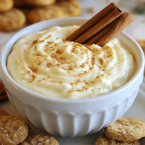 To make this delightful Eggnog Cheesecake Dip, you will need a few simple ingredients. Each one plays a key role in creating that rich, creamy texture and festive flavor. Here’s what you’ll need: - 8 oz cream cheese, softened - 1 cup powdered sugar - 1 cup sour cream - 1 teaspoon vanilla extract - 1/2 teaspoon ground nutmeg - 1/2 teaspoon ground cinnamon - 1/2 cup whipped cream, for folding - Gingersnap cookies, for serving - Optional: crushed nutmeg and cinnamon sticks for garnish Each ingredient combines to create a festive dip that tastes just like eggnog. The cream cheese gives it a rich base, while the powdered sugar adds sweetness. Sour cream brings a nice tang, balancing the flavors perfectly. Vanilla extract enhances the taste, making it warm and inviting. Don’t forget the spices! Ground nutmeg and cinnamon are must-haves for that classic holiday flavor. The whipped cream lightens the dip and makes it fluffy. Gingersnap cookies are the perfect companion for dipping, adding a spicy crunch. Feel free to get creative with the optional garnishes like crushed nutmeg or cinnamon sticks. They make your dip look even more festive! {{ingredient_image_1}} - Mixing the cream cheese Start by taking 8 ounces of softened cream cheese. Place it in a large mixing bowl. Use an electric mixer to beat it until it is smooth. This step helps create a creamy base for the dip. - Adding powdered sugar Gradually add 1 cup of powdered sugar to the cream cheese. Mix it in until the sugar is fully combined. This makes the dip sweet and adds to its creamy texture. - Incorporating sour cream and vanilla Pour in 1 cup of sour cream and 1 teaspoon of vanilla extract. Mix these ingredients until everything is well blended. The sour cream adds a nice tang to the dip. - Flavoring with spices Sprinkle in 1/2 teaspoon of ground nutmeg and 1/2 teaspoon of ground cinnamon. Stir until the spices are evenly mixed. These spices give the dip that classic eggnog flavor. - Folding in whipped cream Gently fold in 1/2 cup of whipped cream. Use a spatula to combine the whipped cream lightly. This step makes the dip airy and fluffy. - Serving suggestions Transfer the dip into a serving bowl. Smooth the top with a spatula. If you want, sprinkle some crushed nutmeg on top. You can also add cinnamon sticks as a garnish. Serve the dip with gingersnap cookies for a tasty treat. Enjoy your festive eggnog cheesecake dip! To make the best Eggnog Cheesecake Dip, start with softened cream cheese. Softened cream cheese mixes easily and gives a smooth dip. If it’s too cold, your dip will be lumpy. Leave it out for about 30 minutes before mixing. Next, when you fold in the whipped cream, do it gently. Use a spatula to lift the cream from the bottom. This keeps the dip light and fluffy. If you stir too hard, your dip will lose its airy feel. If your dip is too sweet, you can adjust the sweetness. Add a pinch of salt or more spices. This will balance the flavors and make it taste even better. To boost the flavor, consider adding extra spices. A dash of cloves or allspice can enhance the warmth of the dip. You can also try a bit of vanilla bean paste for a richer taste. Using flavored whipped toppings is another fun idea. A vanilla or cinnamon-flavored topping can add a new layer of flavor. This small change can make your dip stand out. Pro Tips Use Room Temperature Ingredients: Ensure your cream cheese and sour cream are at room temperature for a smoother, creamier dip. Experiment with Spices: Adjust the nutmeg and cinnamon to your taste, or add a pinch of clove for a more complex flavor profile. Chill Before Serving: Allowing the dip to chill in the refrigerator for an hour enhances the flavors and improves the texture. Garnish Creatively: Get creative with your garnishes! Use crushed gingersnap cookies or whipped cream for an extra festive touch. {{image_2}} You can switch things up with fun flavors. One popular twist is the pumpkin spice version. Just add pumpkin puree and a bit more cinnamon. This gives a cozy fall taste. Another great option is the chocolate eggnog dip. Mix in some cocoa powder for a rich, sweet treat. Both of these variations keep the creamy goodness while adding new flavors. You don’t have to stick to gingersnap cookies. Try pairing the dip with different cookies. Sugar cookies, gingerbread, or even shortbread work well. Each cookie brings its own charm to the dip. You can also use the dip as a spread for desserts. Spread it on graham crackers or a slice of cake. This adds a festive touch to any dessert table. To keep your eggnog cheesecake dip fresh, store it in the fridge. Use an airtight container. This will help keep it from drying out. You can also cover it tightly with plastic wrap. If you want to save it for later, you can freeze it. Just put it in a freezer-safe container. Make sure to leave some space at the top for expansion. The dip stays fresh in the fridge for about 3 to 5 days. If you freeze it, it can last up to 2 months. When you're ready to eat it, just thaw it in the fridge overnight. After thawing, it’s best to enjoy it in a few days. If it looks or smells off, toss it. Always check for freshness before serving. Yes, you can make this dip ahead of time. It tastes even better after chilling. I suggest making it a few hours before your event. Just cover it and store it in the fridge. This way, the flavors blend well. When it's time to serve, you can add the whipped cream and garnishes. If you need a substitute for sour cream, try Greek yogurt. It has a similar texture and tang. You can also use crème fraîche. Both options work well in this dip. Just use the same amount as the sour cream in the recipe. Absolutely! You can create a non-dairy version. Use non-dairy cream cheese instead of regular cream cheese. For sour cream, use non-dairy yogurt. Also, choose a non-dairy whipped topping for the whipped cream. These swaps keep the flavor rich and creamy without dairy. This article covered how to make Eggnog Cheesecake Dip. We discussed ingredients, step-by-step instructions, and tips for the best texture. You can try tasty variations, like pumpkin spice or chocolate. Proper storage keeps the dip fresh longer. In my view, this dip is perfect for gatherings or cozy nights in. Enjoy mixing flavors and sharing with friends. Happy dipping!